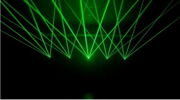 Green laser beam fans in a dark room