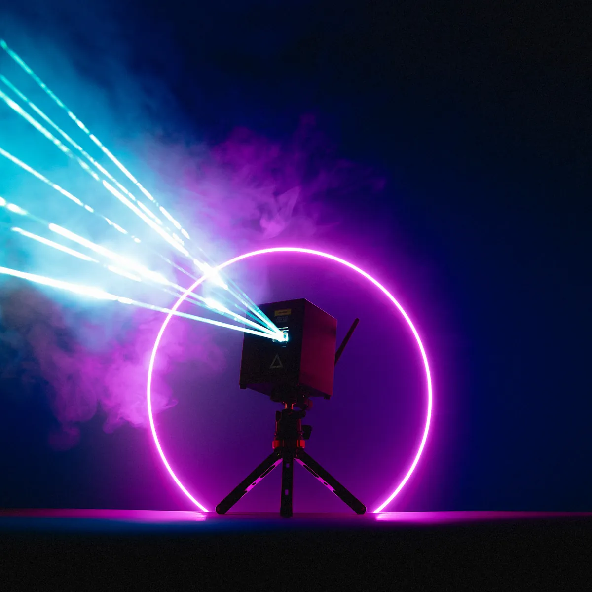 Lasercube with purple strobe light circle projecting lasers in a dark environment.