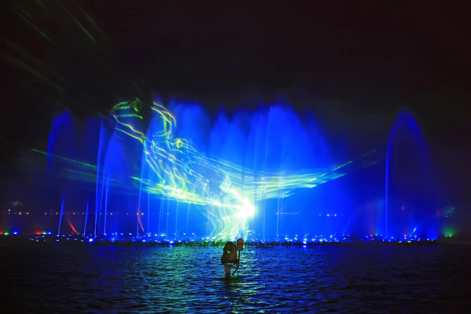 Laser images on a fountain water curtain at night