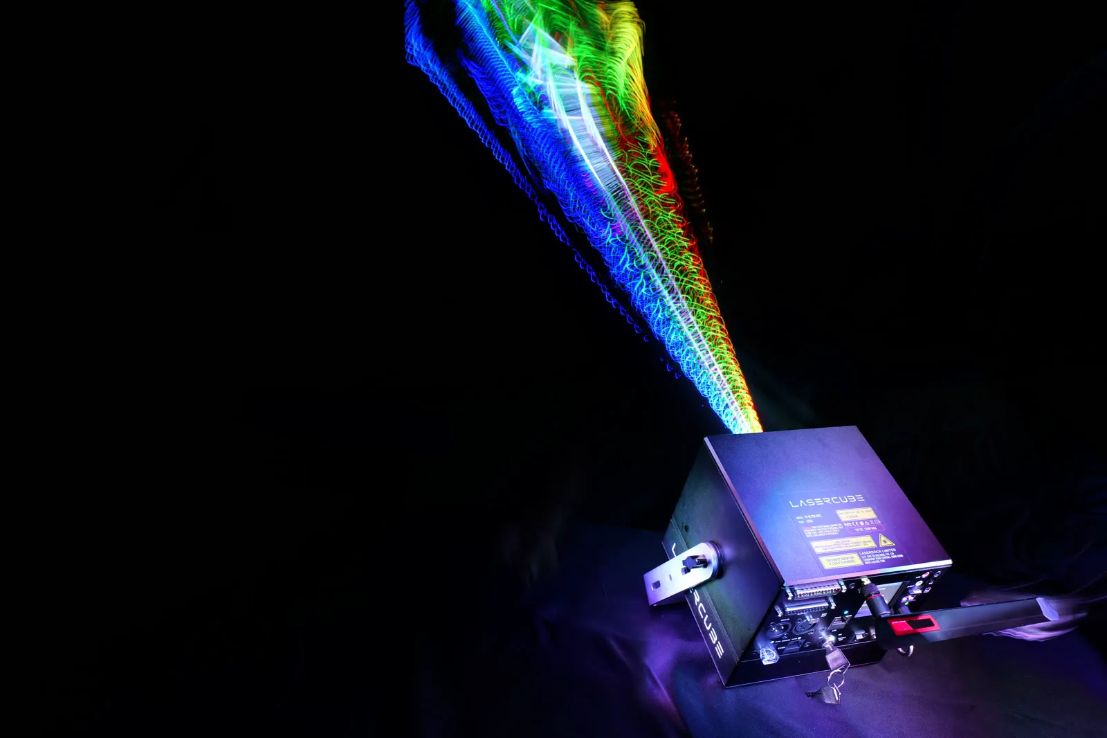 Long-exposure photo of a LaserCube Ultra MK2 projecting colored laser light